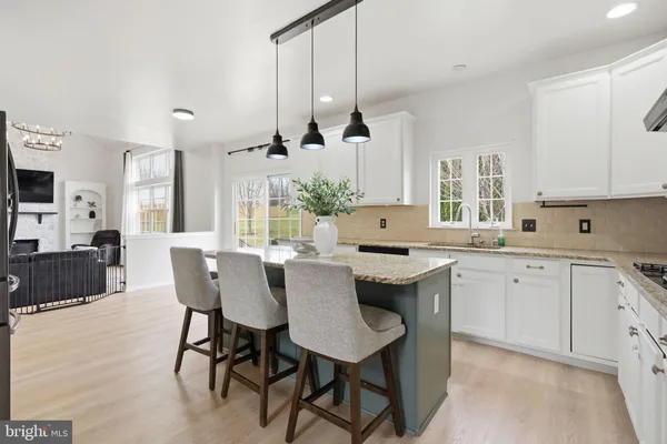 a kitchen with granite countertop a sink a stove and cabinets