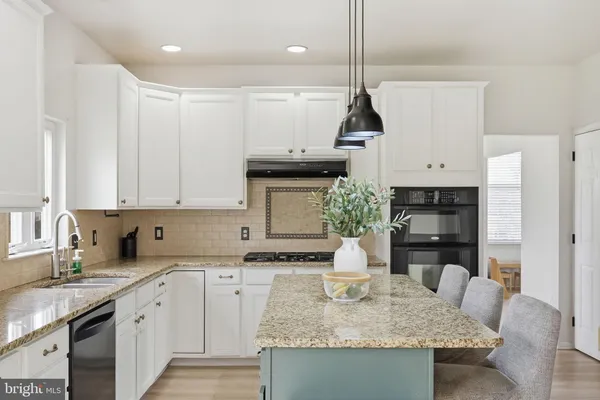 a kitchen with granite countertop a sink a stove and lots of counter top space