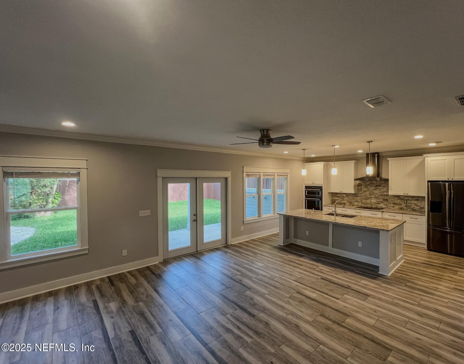 4325 Appleton Avenue Jacksonville, FL 32210 - Photo 5 of 40 a large living room with kitchen island granite countertop wooden floor stainless steel appliances and windows