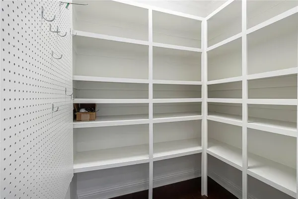 a kitchen with white cabinets and wooden floor