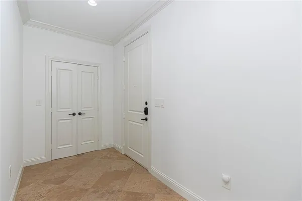 a view of an empty room with wooden floor and a ceiling fan