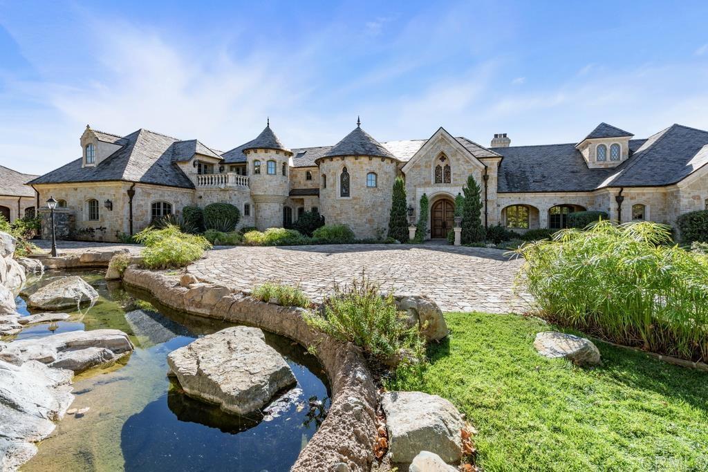 18441 Via Ambiente Rancho Santa Fe, CA 92067 - Photo 28 of 35 a front view of a house with a yard and garage