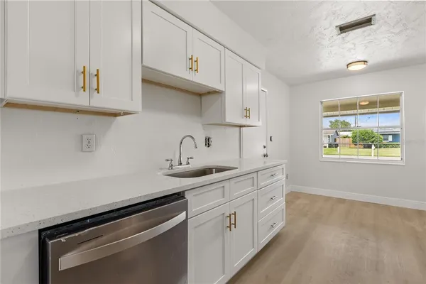 a kitchen with stainless steel appliances white cabinets and a sink