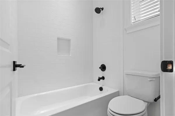 an empty room with windows and bathroom