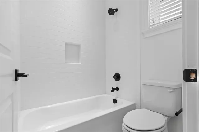 an empty room with windows and bathroom