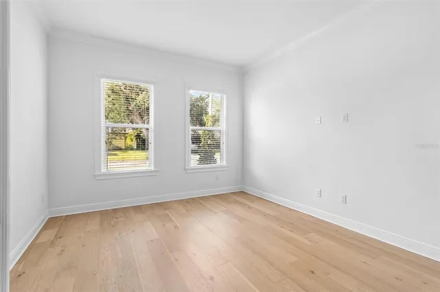 an empty room with wooden floor and white walls