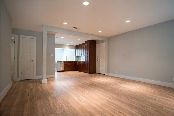 a view of empty room with wooden floor
