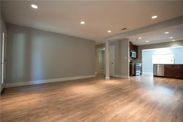 a view of a big room with wooden floor and windows