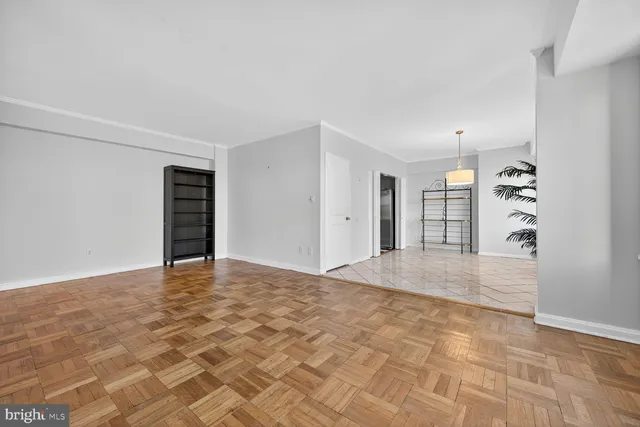 a view of an empty room with closet and a window