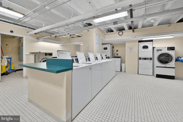 a kitchen with stainless steel appliances kitchen island granite countertop lots of white cabinets a refrigerator and a stove