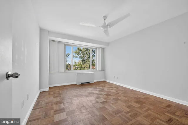 an empty room with windows and closet