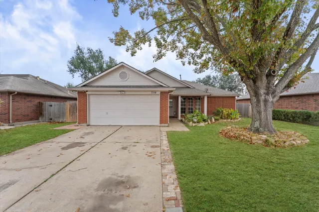 a front view of a house with a garden and trees