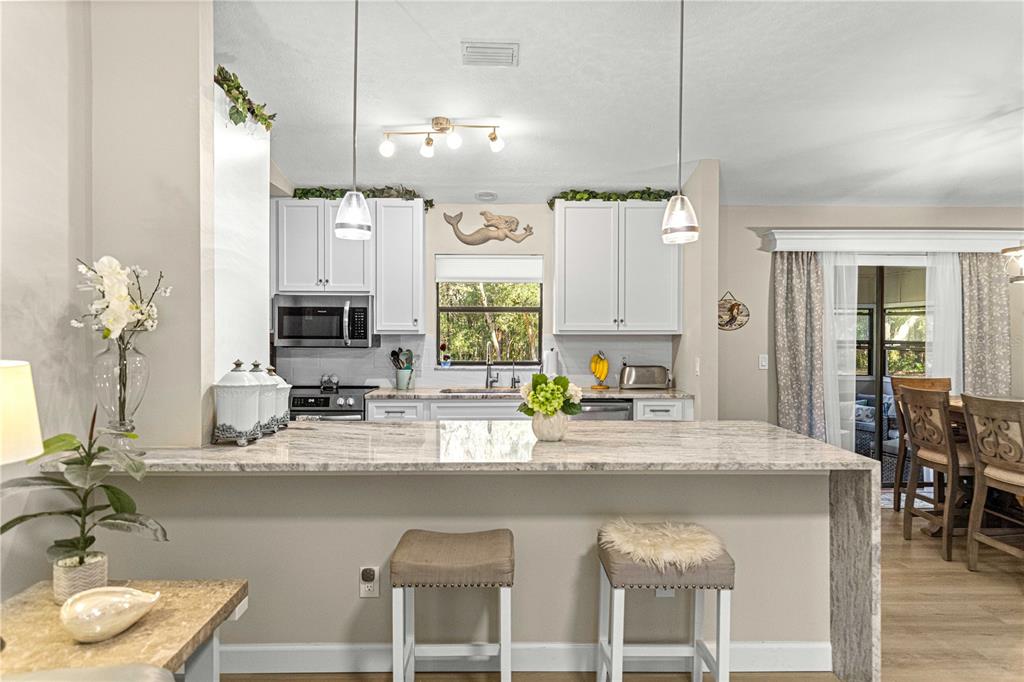 1155 East Bismark Street Hernando, FL 34442 - Photo 5 of 52 a kitchen with stainless steel appliances granite countertop a sink a stove and a wooden floors