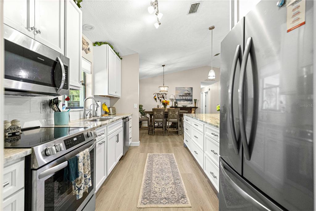 1155 East Bismark Street Hernando, FL 34442 - Photo 8 of 52 a large kitchen with stainless steel appliances granite countertop a stove a sink and a refrigerator