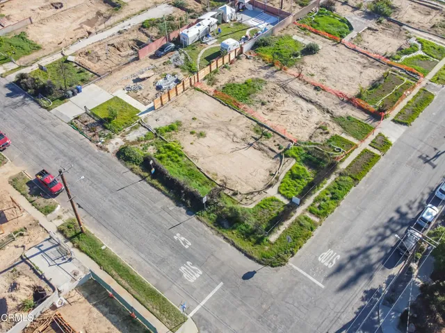 an aerial view of residential houses with outdoor space and street view