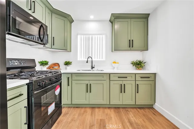 a kitchen with stainless steel appliances granite countertop a stove a sink and a microwave