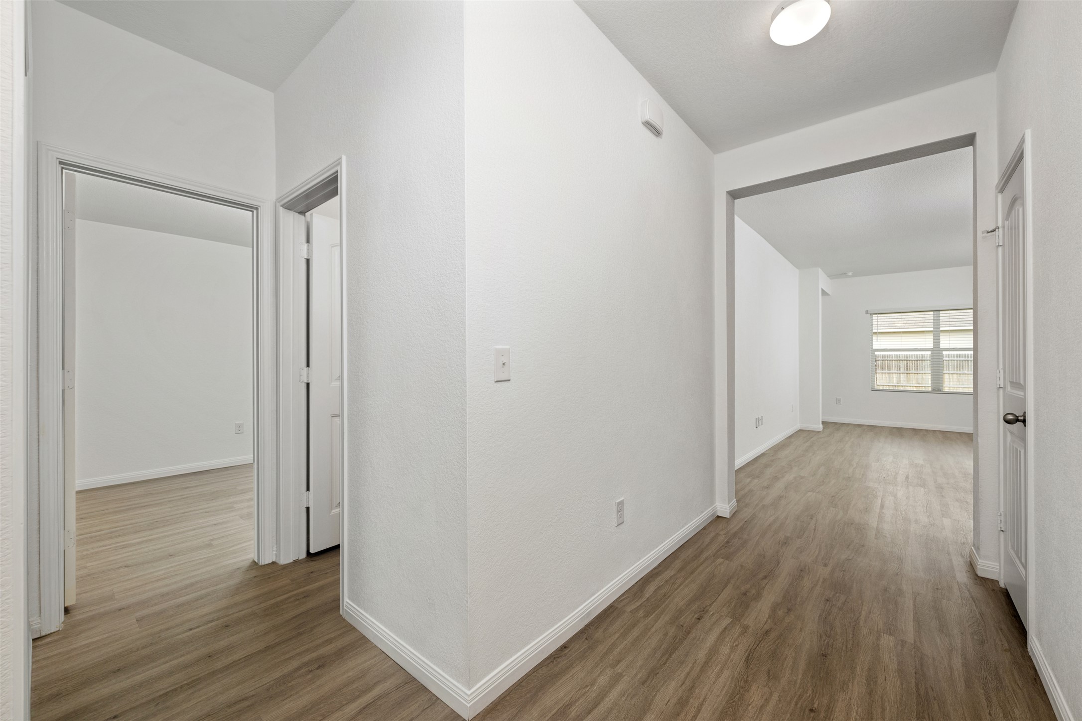 14900 Retha Pass Austin, TX 78725 - Photo 23 of 39 Interior hallway featuring wood-finish flooring, white walls, and white trim