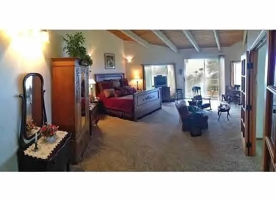 a living room with furniture a flat screen tv and kitchen view