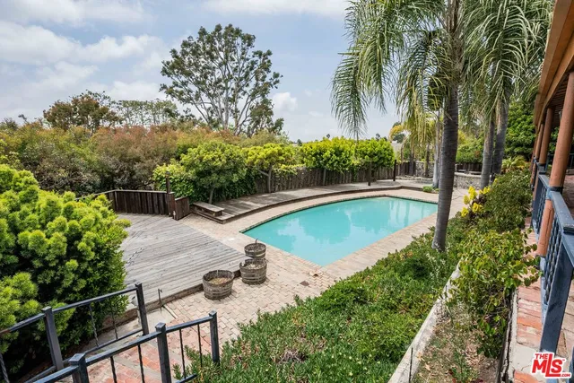 a view of a swimming pool with a patio and a yard