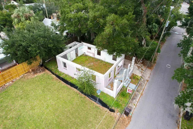 an aerial view of a house with swimming pool and large trees