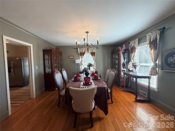 a dining room with furniture a chandelier and wooden floor