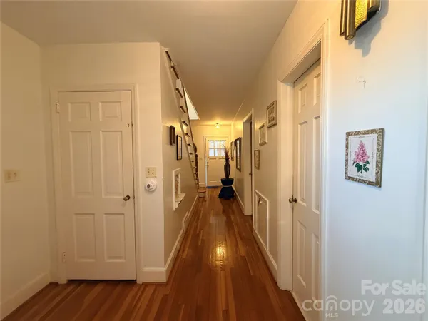 a view of a hallway with wooden floor and staircase