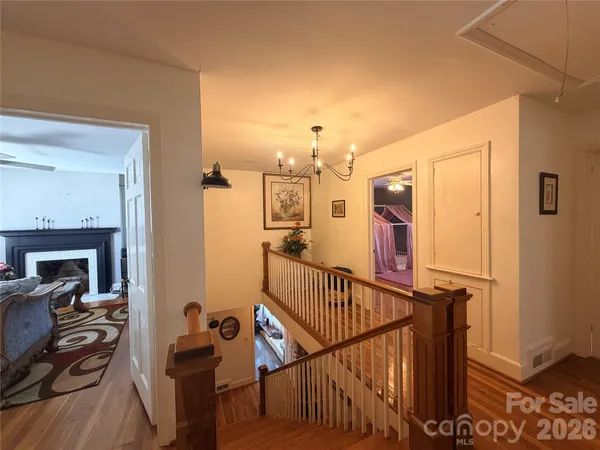 a view of a hallway with workspace and wooden floor