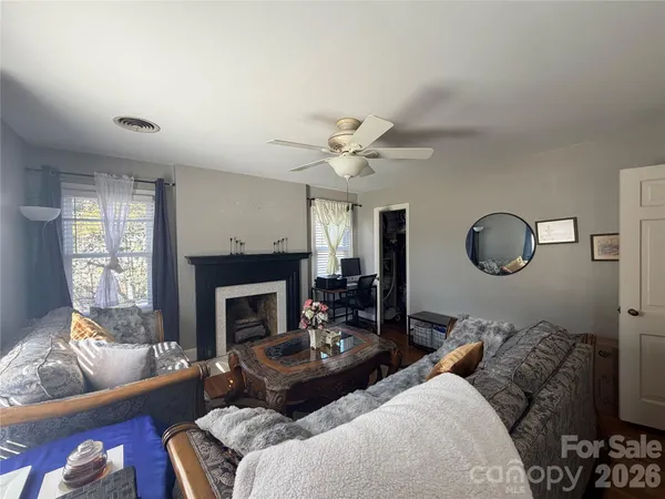 a living room with furniture a fireplace and a large window