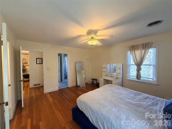a spacious bedroom with a large bed and a chandelier