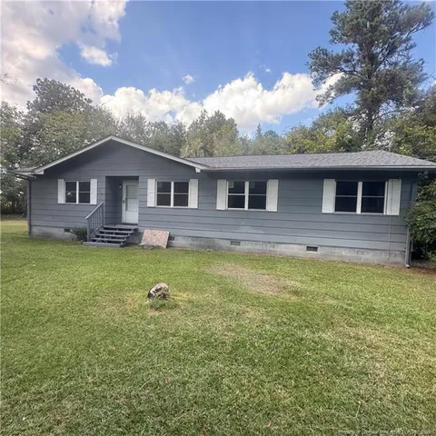 a front view of house with yard and outdoor seating