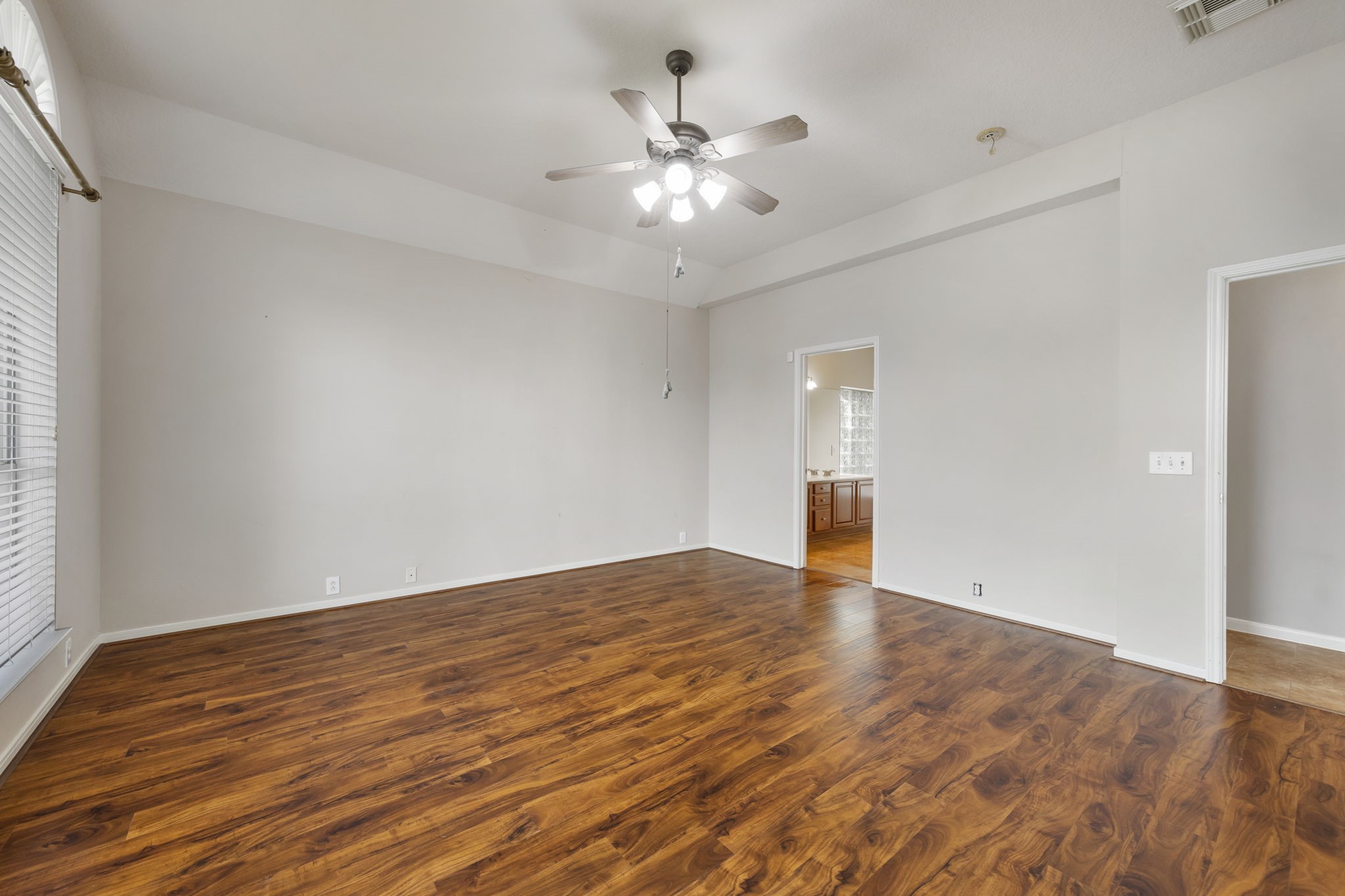 2907 Stemwood Drive Spring, TX 77388 - Photo 14 of 33 Generously sized primary retreat featuring vaulted ceilings, rich wood-look flooring, and direct access to the en-suite bath, offering a comfortable and private escape within the home.