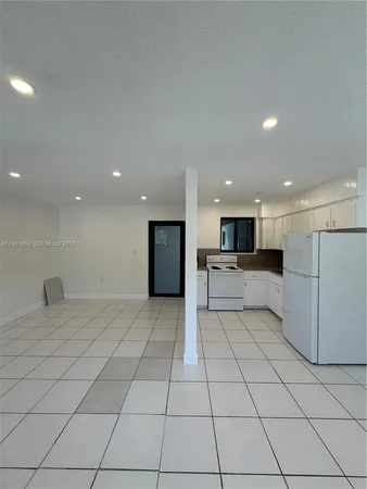 a kitchen with stainless steel appliances a refrigerator sink and white cabinets
