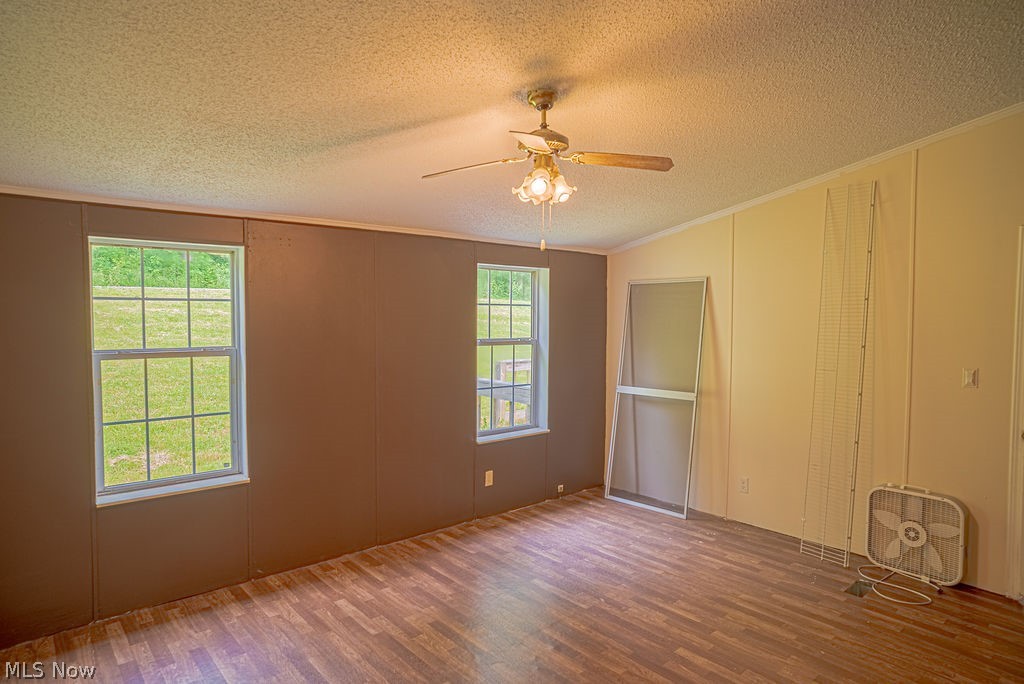967 Buck Run Road Mineral Wells, WV 26150 - Photo 38 of 50 Expansive room featuring wood-finish flooring, multiple windows, a ceiling fan with integrated lighting, and textured ceilings