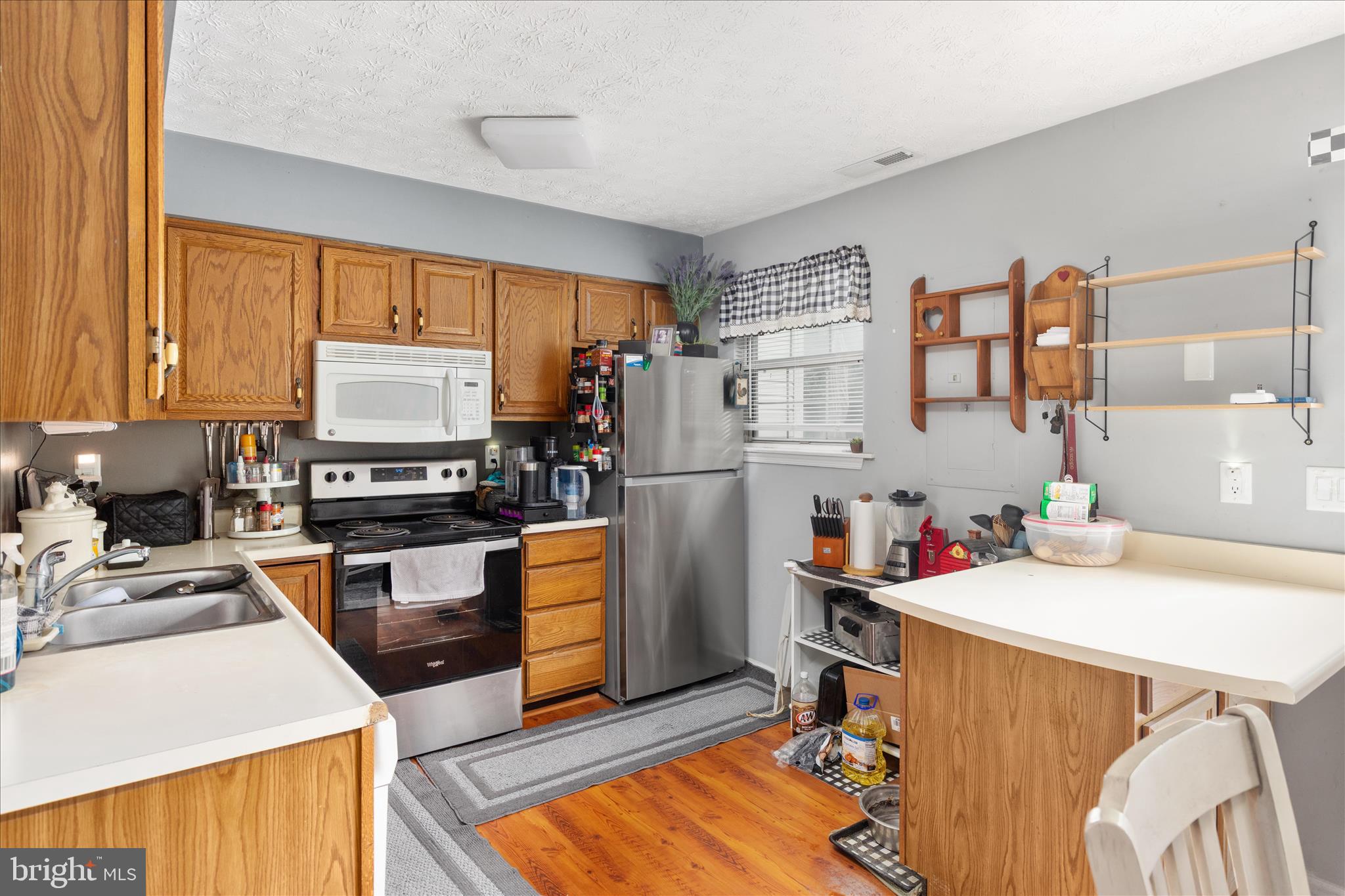 132 Stadium Circle Inwood, WV 25428 - Photo 7 of 25 a kitchen with a refrigerator a stove a sink dishwasher and wooden cabinets with wooden floor