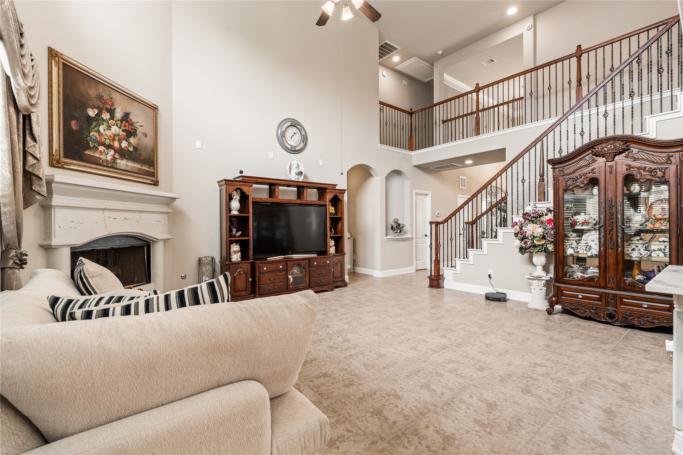5802 Layton Meadows Lane Spring, TX 77379 - Photo 8 of 42 Living room with staircase view. Two-story ceilings, fireplace, entertainment wall, wrought-iron staircase.