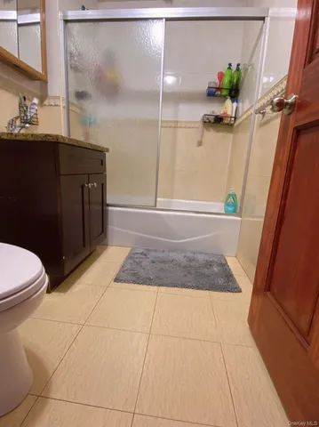 a bathroom with a granite countertop sink a toilet and a mirror