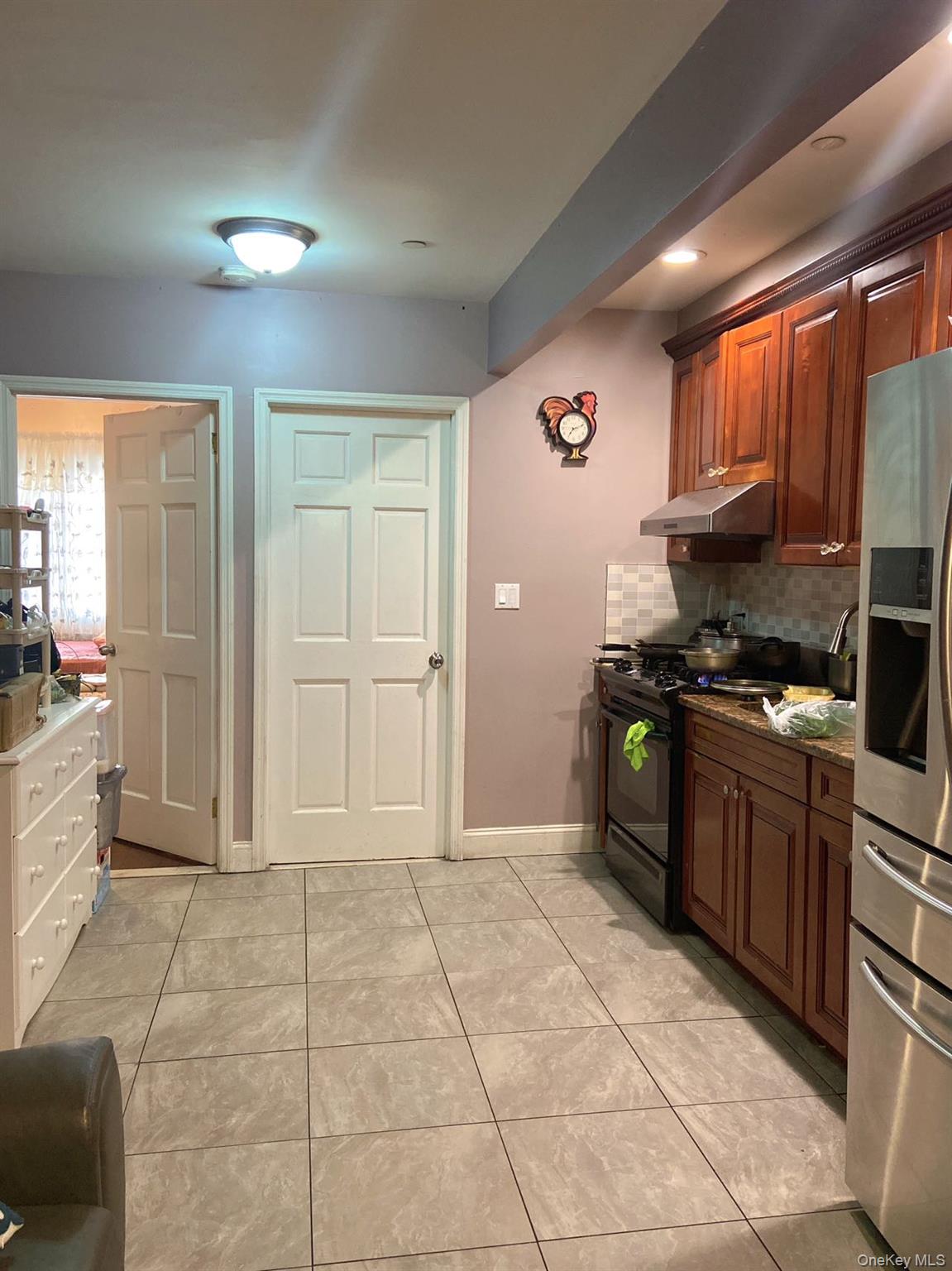 90-19 Corona Avenue Queens, NY 11373 - Photo 9 of 23 a kitchen with granite countertop a stove cabinets and a refrigerator