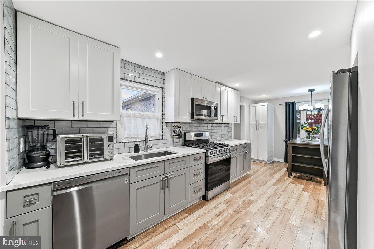 2330 Poe Road Secane, PA 19018 - Photo 13 of 33 a kitchen with stainless steel appliances a stove sink microwave and cabinets