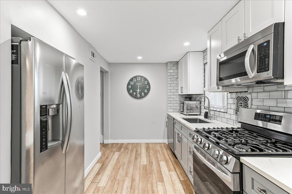 2330 Poe Road Secane, PA 19018 - Photo 15 of 33 a kitchen with stainless steel appliances granite countertop a stove top oven a sink dishwasher a refrigerator and a microwave