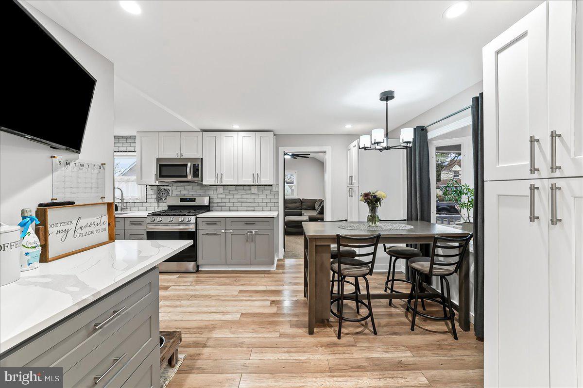 2330 Poe Road Secane, PA 19018 - Photo 16 of 33 a kitchen with stainless steel appliances a stove a sink a microwave a refrigerator and cabinets