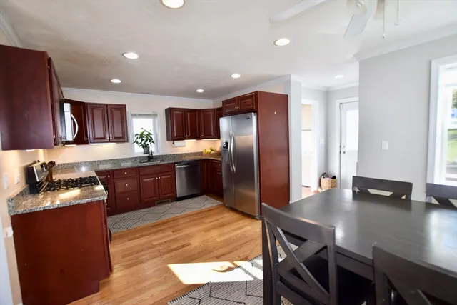 a kitchen with stainless steel appliances granite countertop a sink refrigerator and cabinets
