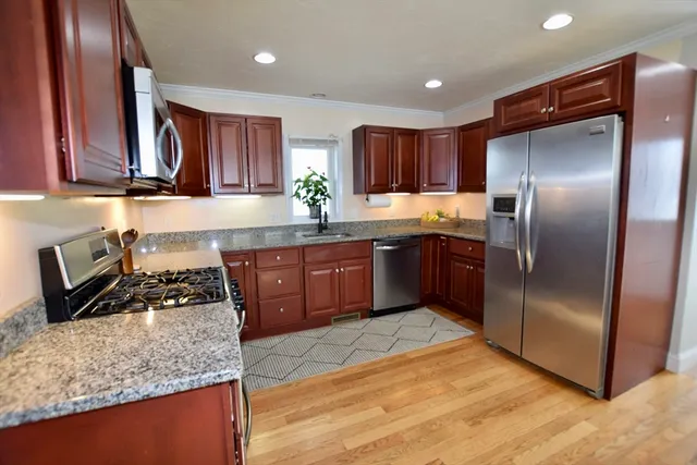 a kitchen with stainless steel appliances granite countertop a sink stove and refrigerator