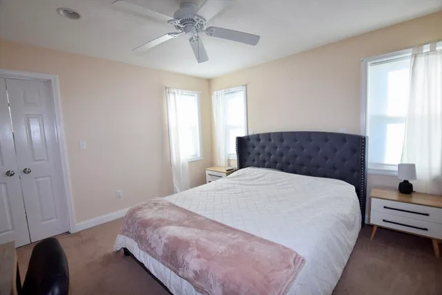 a bedroom with a large bed and a chandelier