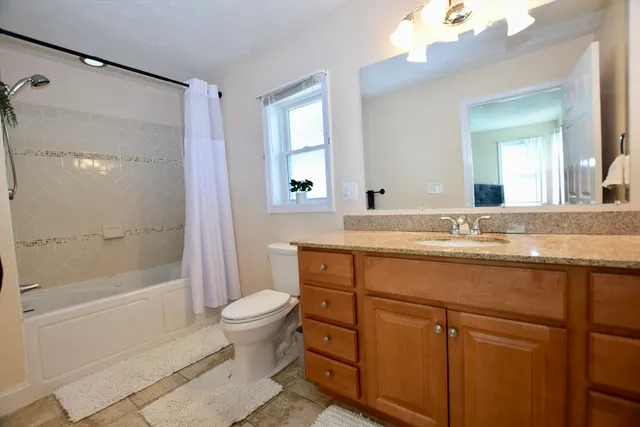 a bathroom with a granite countertop sink toilet and shower