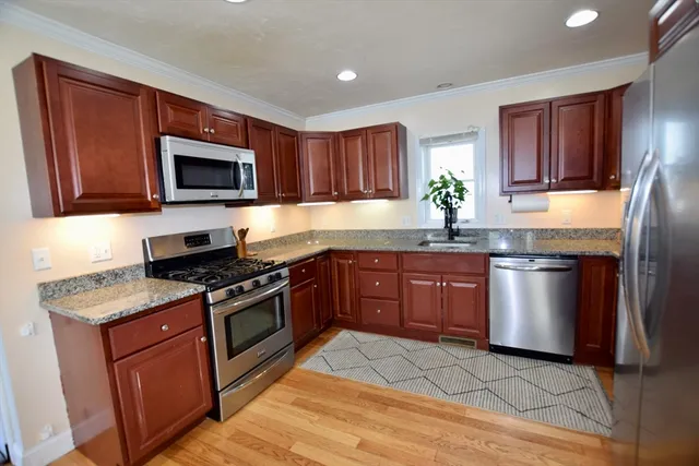 a kitchen with granite countertop a stove top oven microwave and cabinets