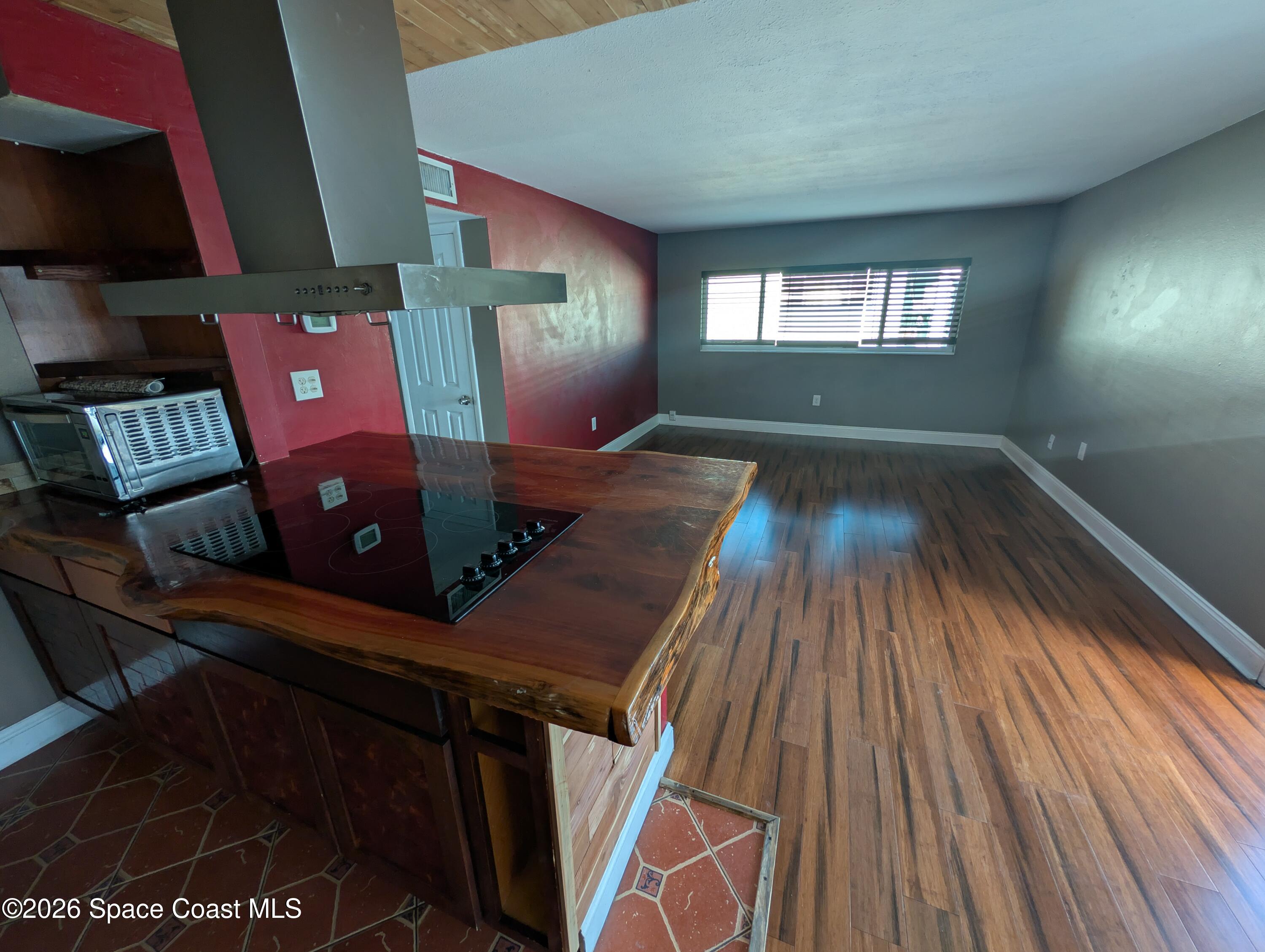 180 Minna Lane, Unit 407 Merritt Island, FL 32953 - Photo 2 of 8 a view of an empty room with wooden floor and a window