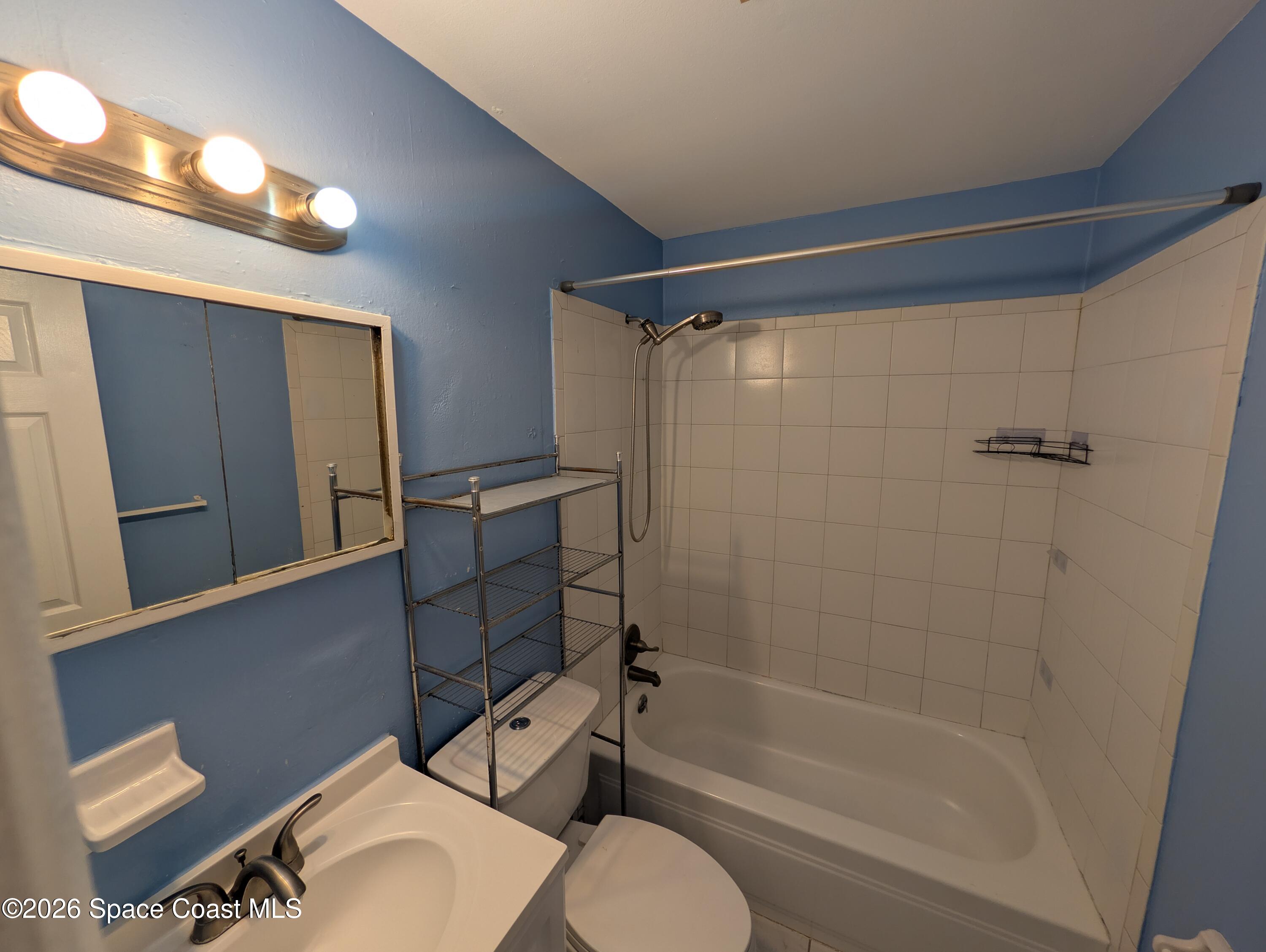 180 Minna Lane, Unit 407 Merritt Island, FL 32953 - Photo 6 of 8 a bathroom with a toilet and a shower