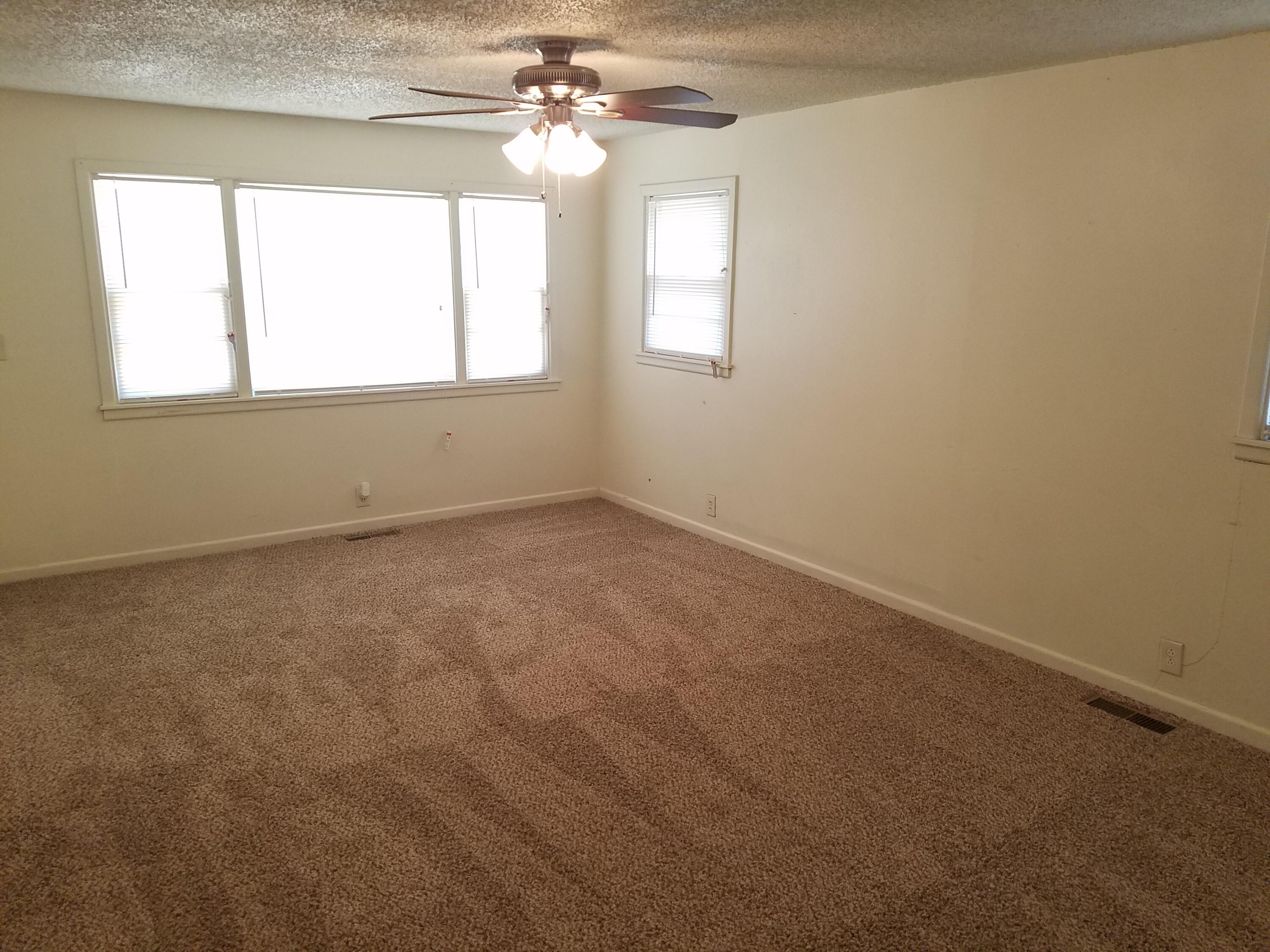 2702 22nd Street Lubbock, TX 79410 - Photo 2 of 9 en empty room with windows and chandelier fan