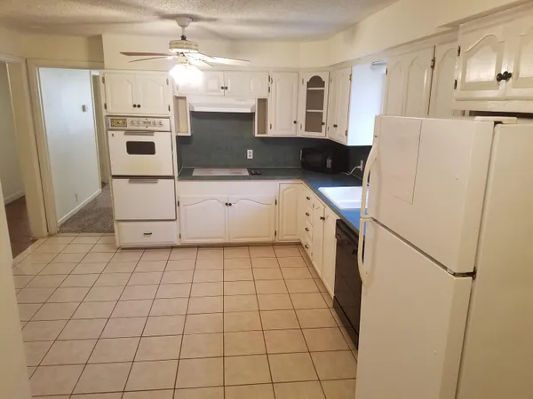 a kitchen with a refrigerator a stove top oven and cabinets