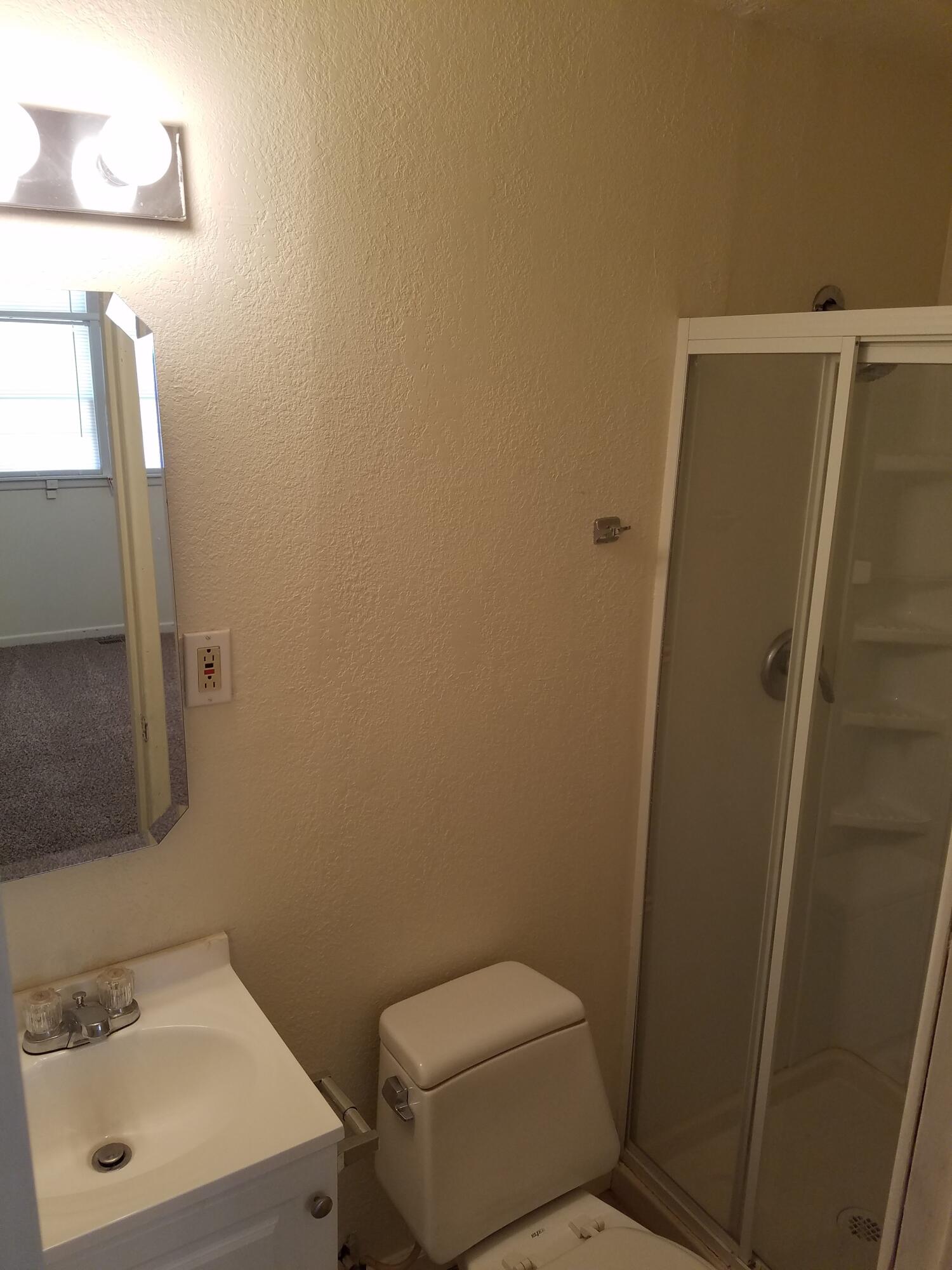 2702 22nd Street Lubbock, TX 79410 - Photo 5 of 9 a bathroom with a toilet sink and mirror